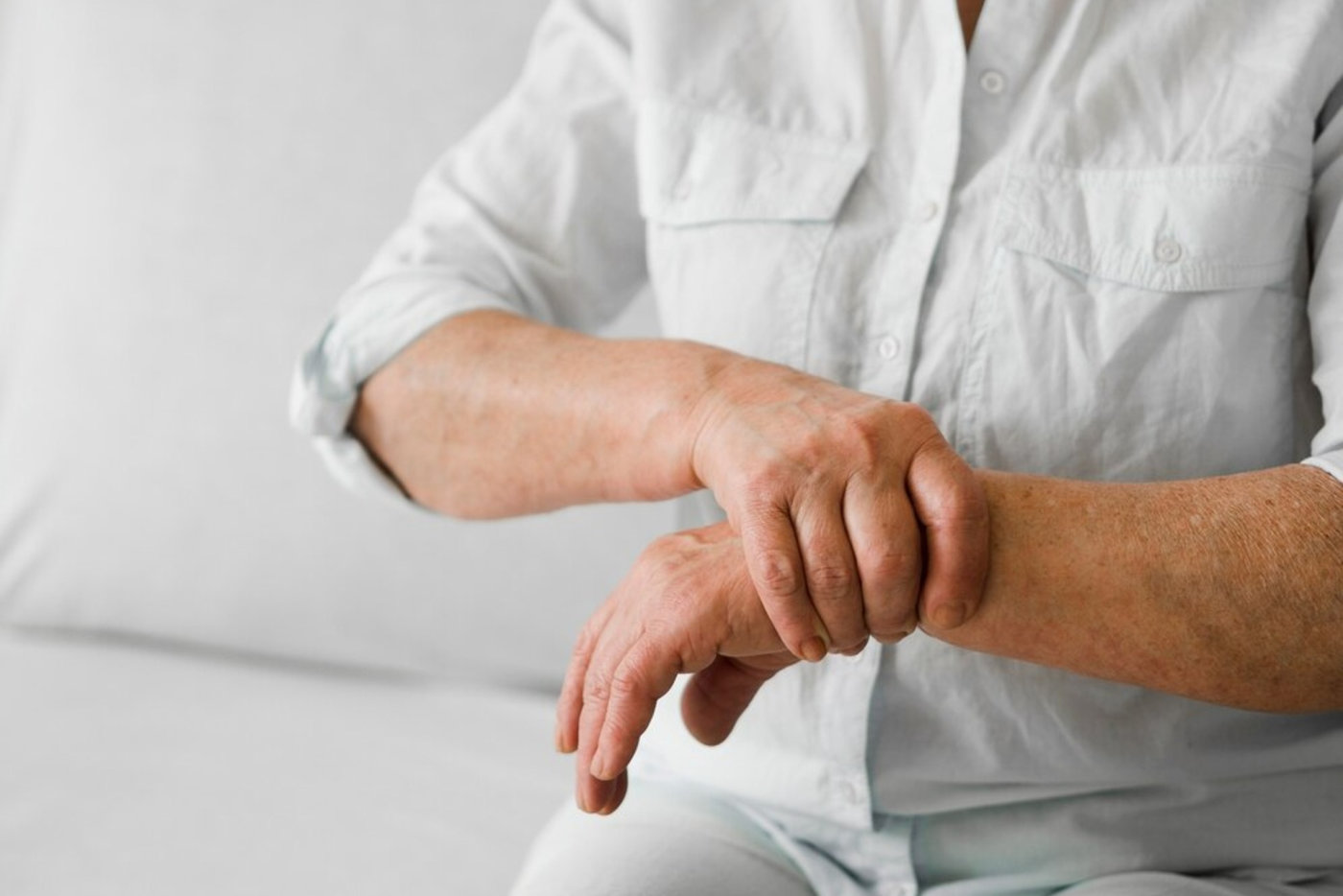 Elderly woman with arthritis holding her hand