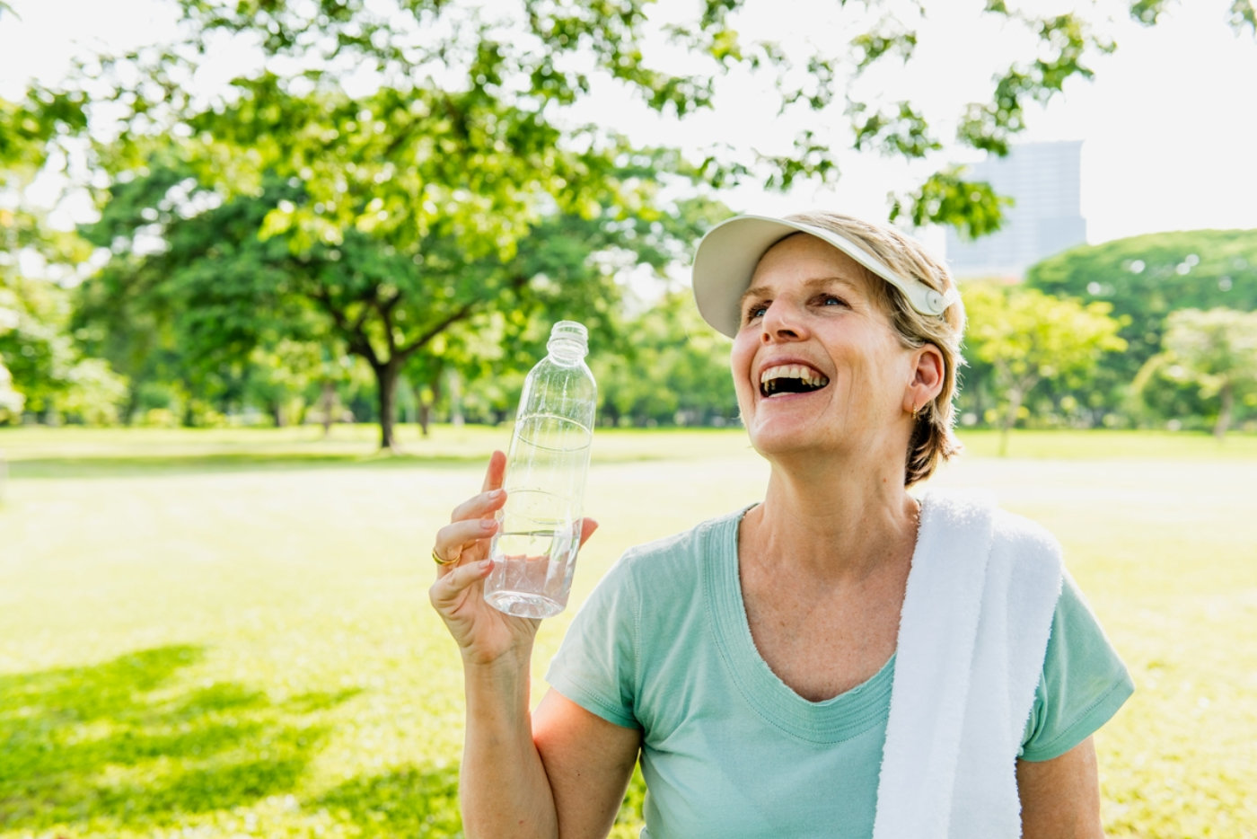 Smiling healthy elderly woman outdoors holding a water bottle